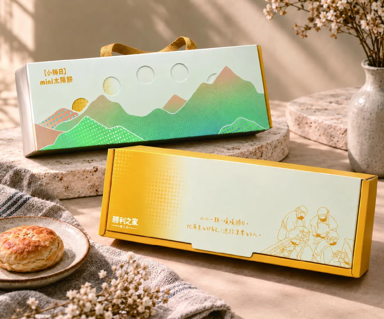 兩款禮盒擺在石材上,旁邊是乾燥花與一顆太陽餅